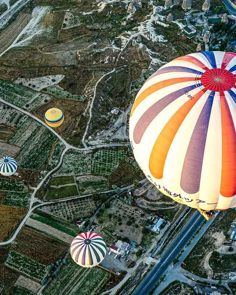 Hot-air balloon drifting over patchwork fields